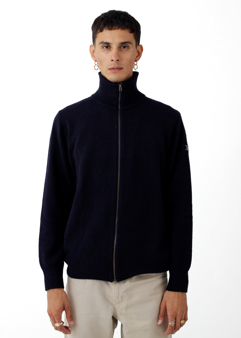 Modelo con jersey IAIOS unisex azul oscuro liso con cremallera completa y cuello alto, tejido con hilo reciclado en pequeños talleres de Catalunya (España).
