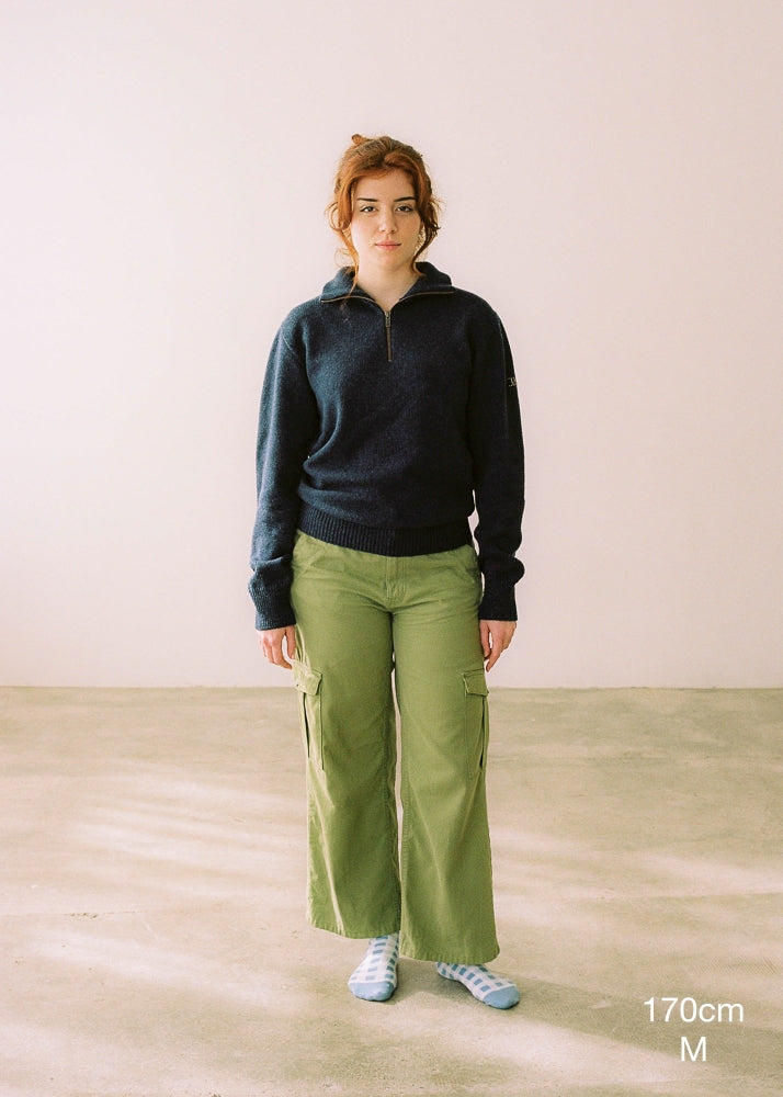 La modelo lleva el jersey IAIOS unisex azul marino con media cremallera, moda sostenible elaborada en talleres de Catalunya (España) con hilo reciclado.