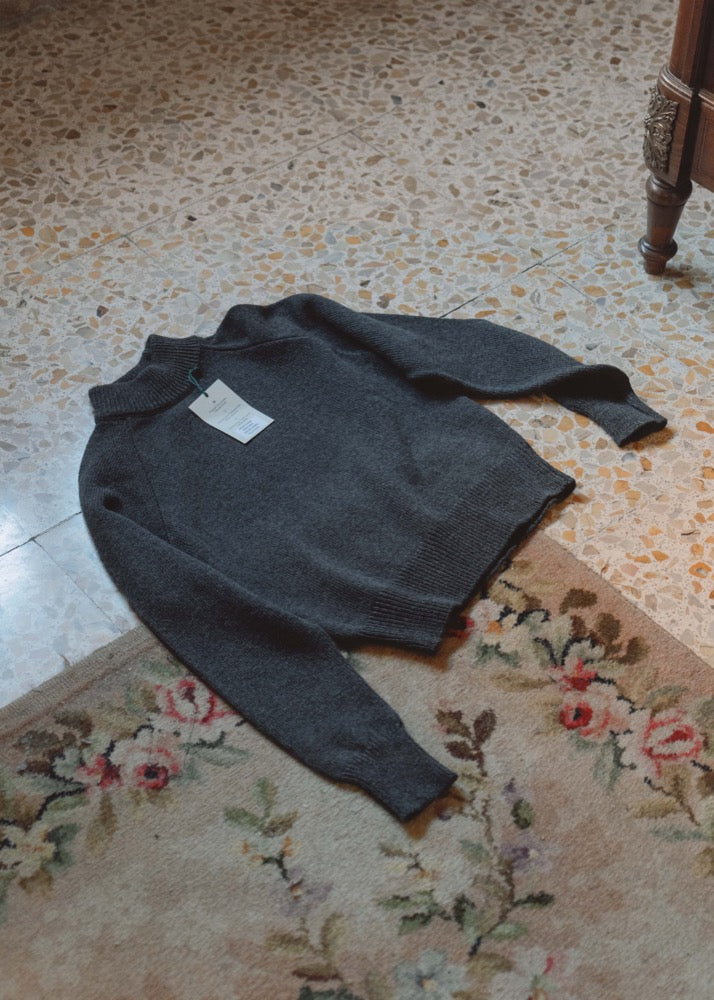 Jersey unisex IAIOS gris oscuro jaspeado con cuello alto y textura suave, fotografía en plano (flat lay), hecho en Catalunya (España) con hilo reciclado.