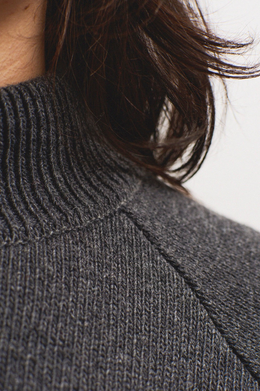 Jersey IAIOS gris oscuro jaspeado con cuello alto, detalle del tejido elaborado con hilo reciclado en talleres de Catalunya (España).