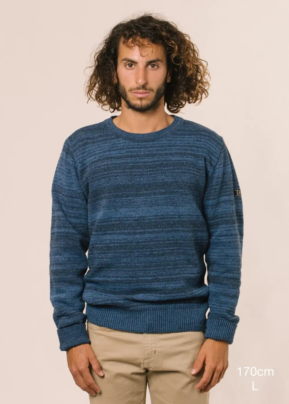 Fotografia de mig cos en la qual es detalla alçada del model (170cm) i talla de la seva jersei (L).
