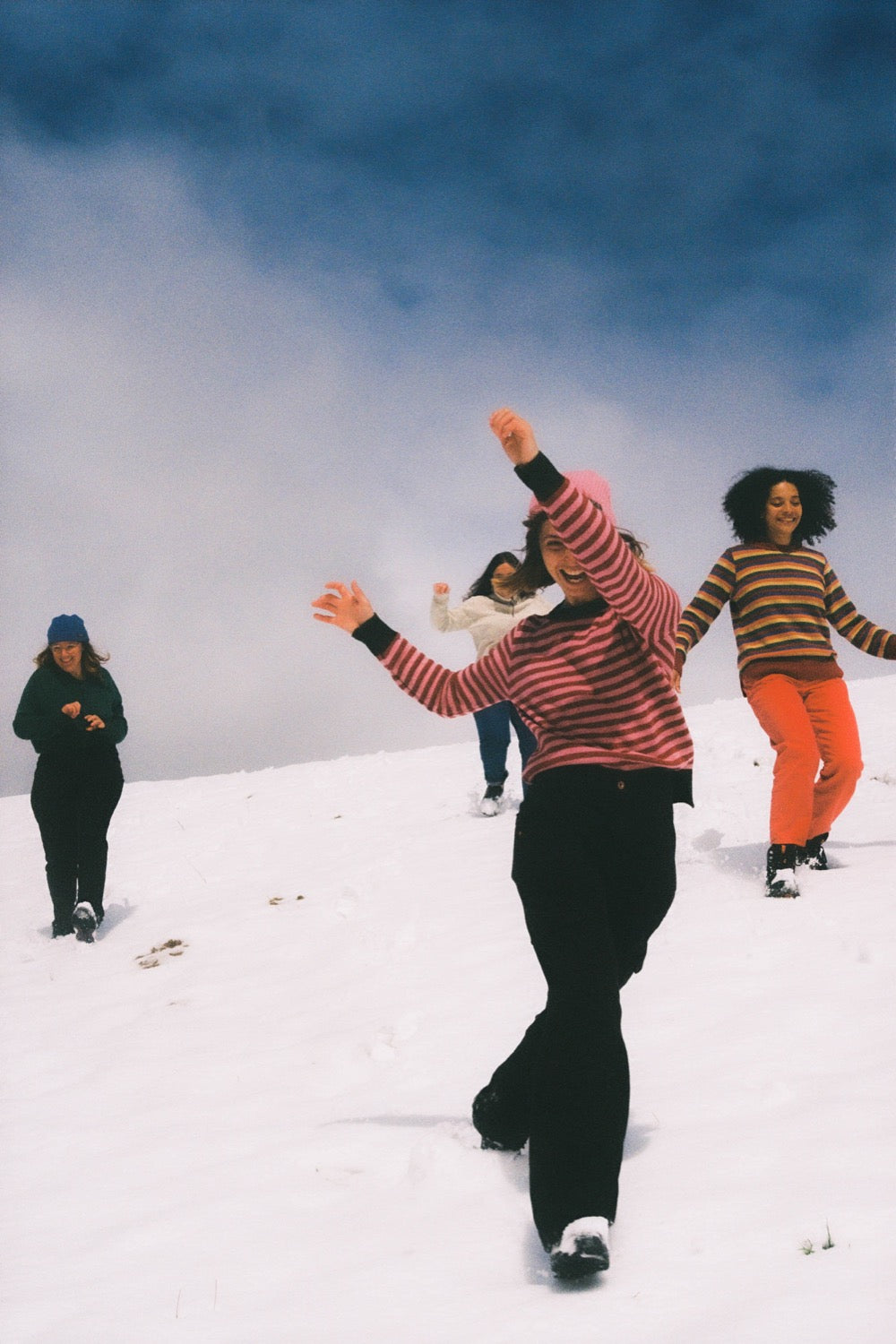 Varias amigas jugando en la nieve con el jersey de rayas