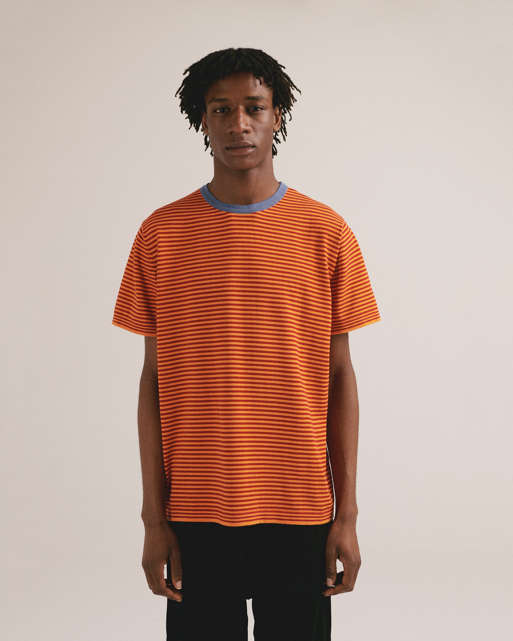 Camiseta de punto de rayas con tonos naranja y cuello azul. Algodón orgánico y fabricación local.