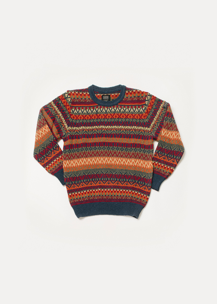 Jersey de punto de hombre o unisex de tonos rojos, naranjas y azules. Es un jacquard de 5 colores por lo que se consigue un resultado de jersey navideño.