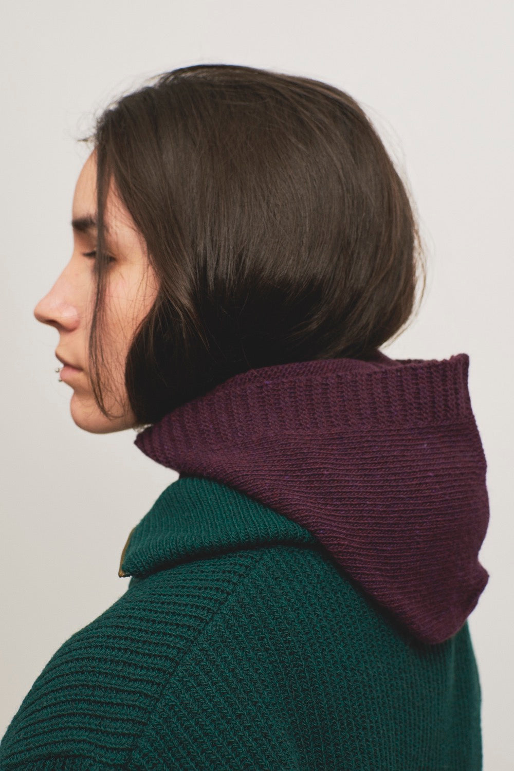 Balaclava o pasamontañas color vino o burdeos puesto para atrás a modo de capucha.