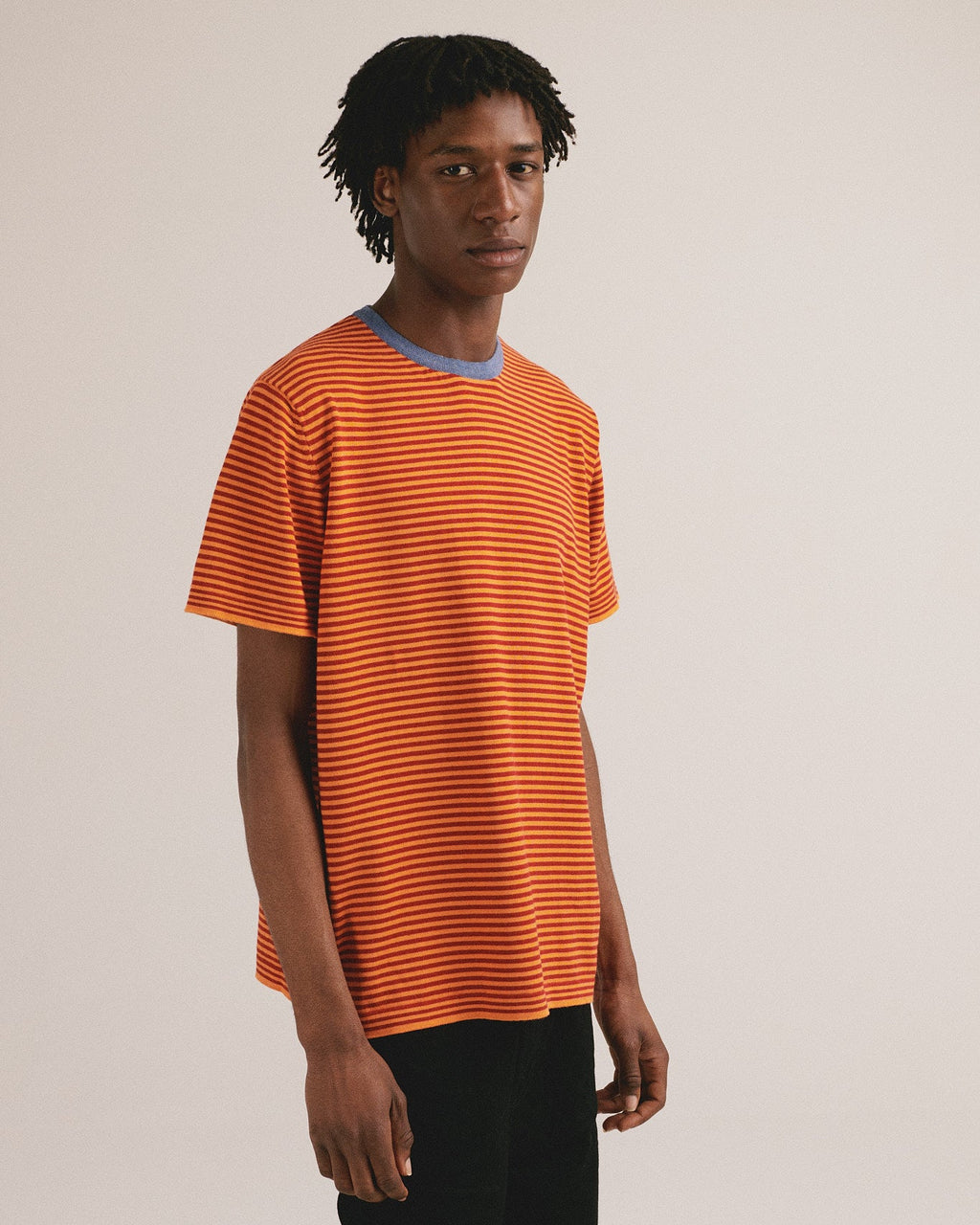 Camiseta de punto de rayas con tonos naranja y cuello azul. Algodón orgánico y fabricación local.
