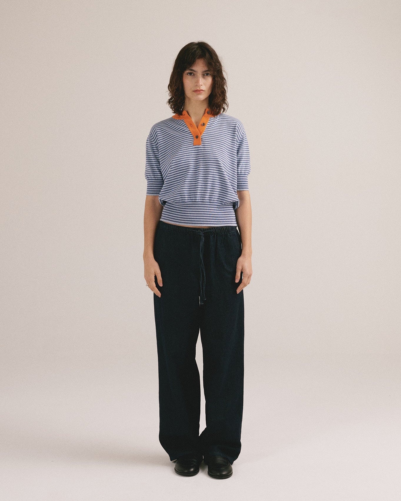 Polo de rayas azul y naranja para mujer con cuello de botones. 