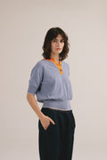 Polo de rayas azul y naranja para mujer con cuello de botones. 