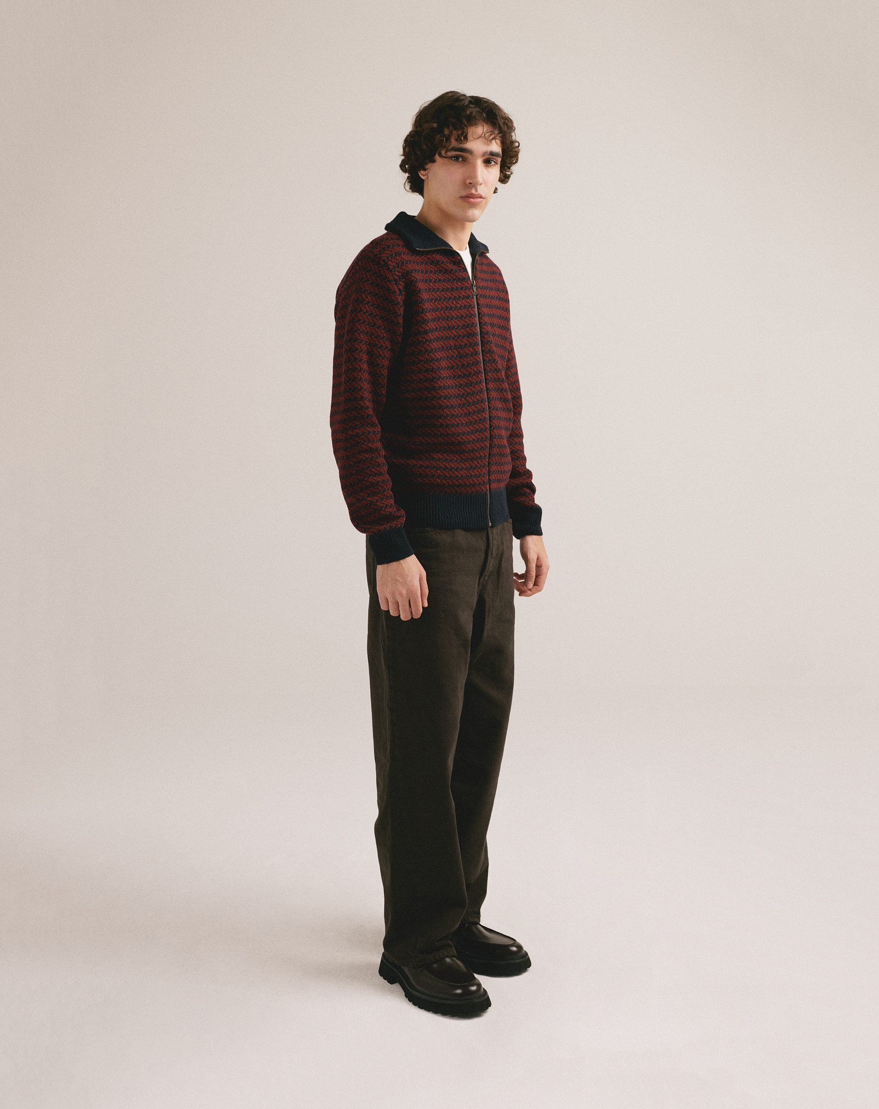 Modelo masculino con chaqueta de punto bicolor con textura jaspeada y cierre frontal de cremallera de IAIOS.