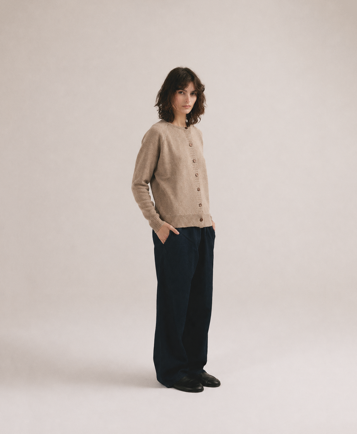 Modelo femenina con chaqueta de punto beige de manga larga con botones frontales de IAIOS.
