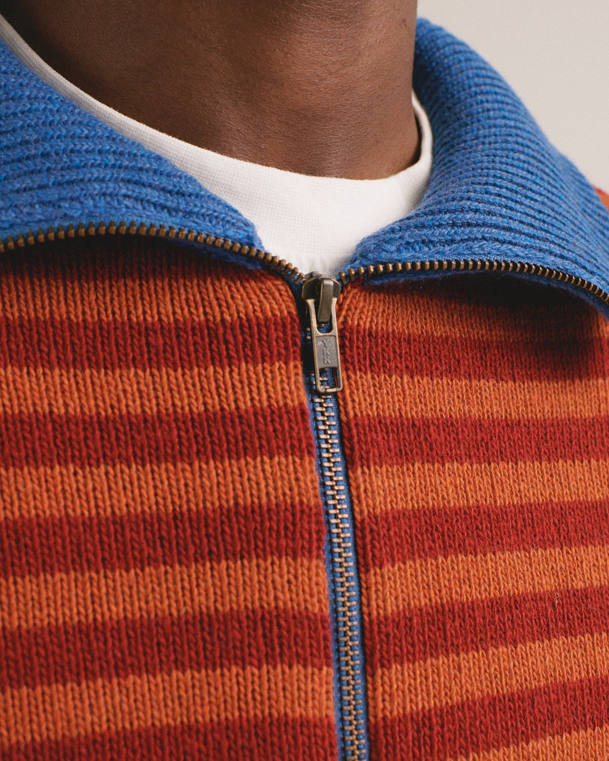Detalle del cuello del jersey de rayas naranja con cremallera Truth de IAIOS