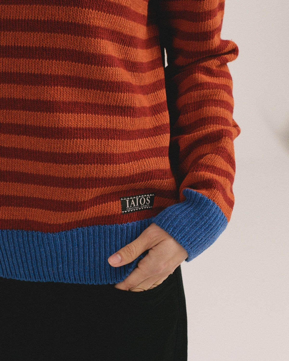 Detalle del bajo del jersey de rayas naranja Truth de IAIOS para mujer