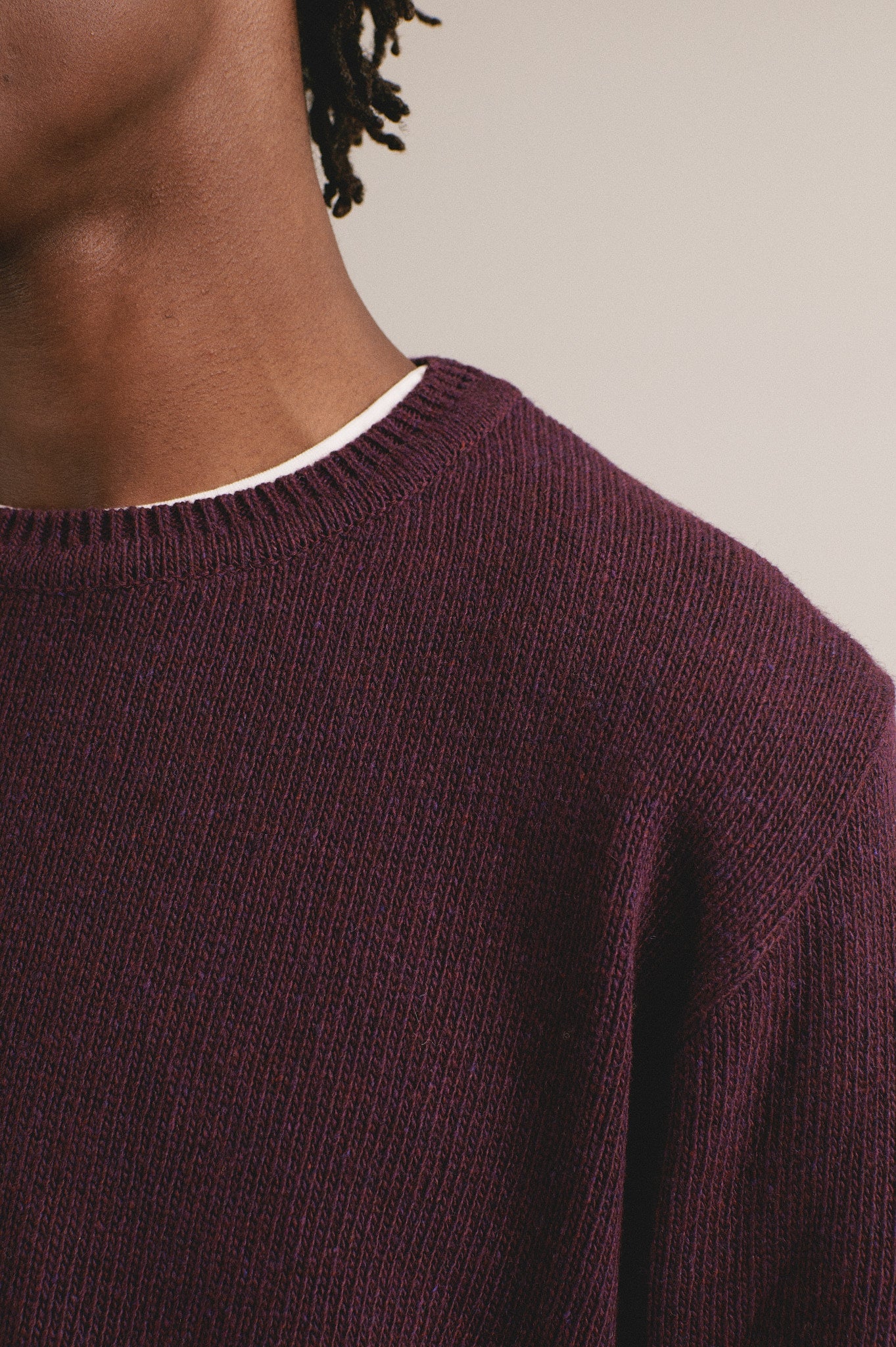 Detalle del jersey de punto para hombre en color berenjena con diseño sencillo, ideal para otoño invierno.