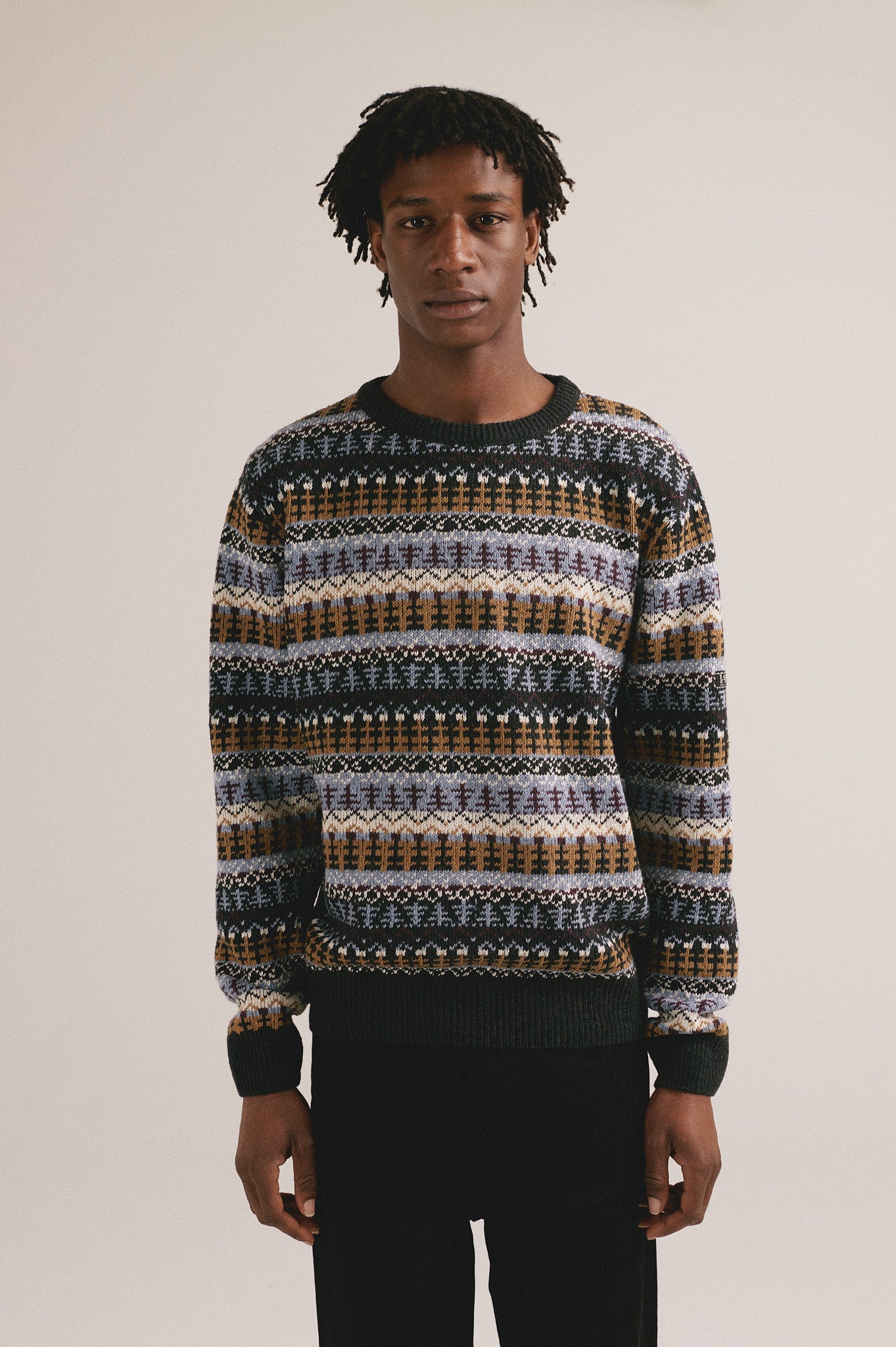 Jersey multicolor de punto para hombre con estampado étnico y textura cálida.