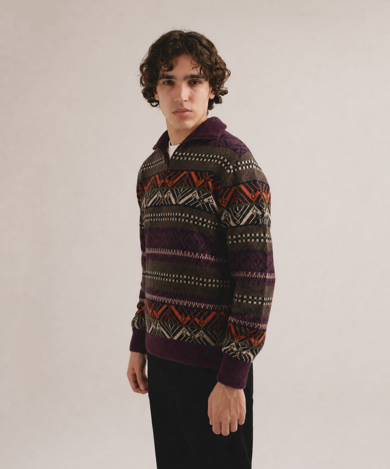 Hombre con jersey multicolor de punto con patrón étnico y cuello con cremallera