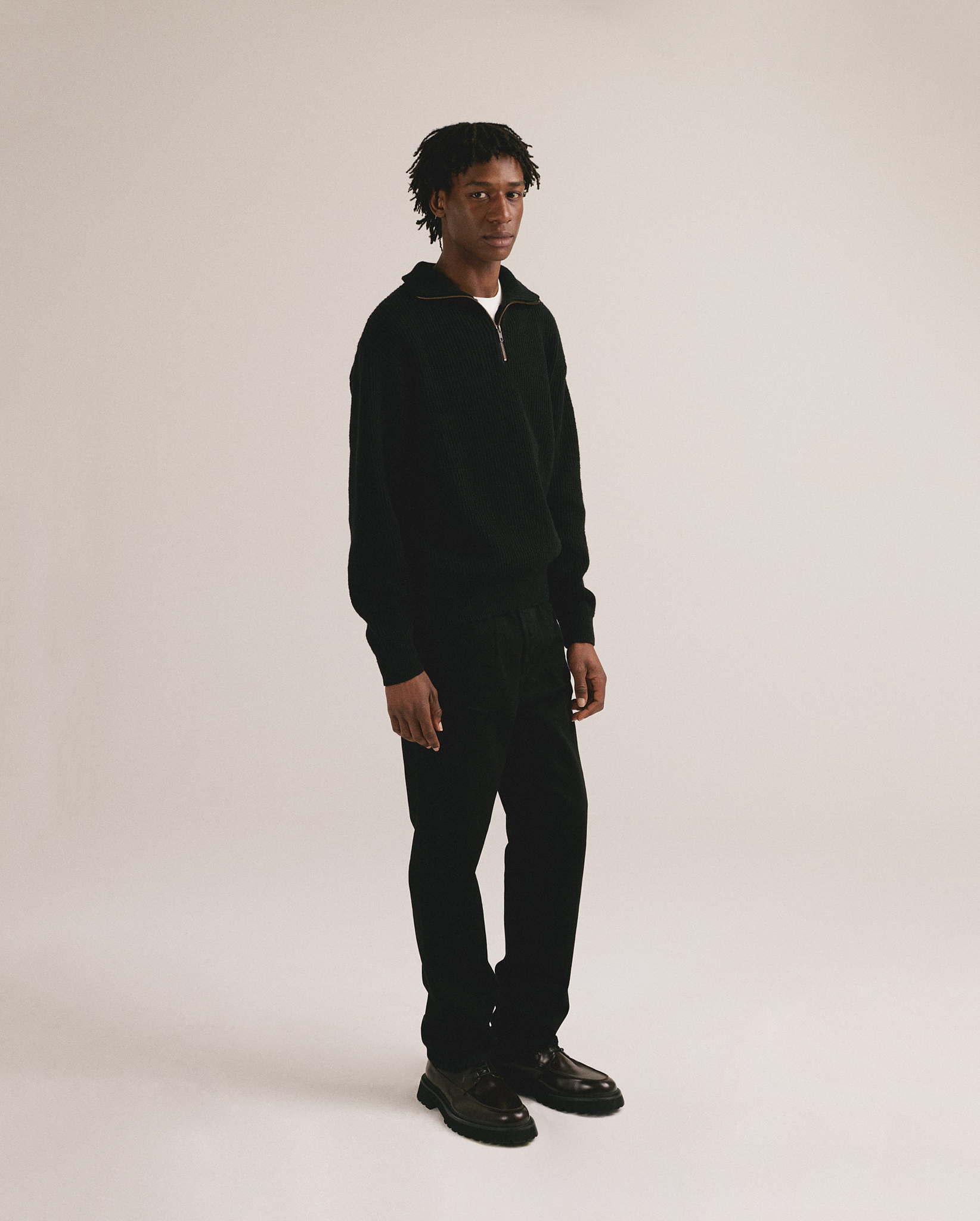 Jersey negro de punto para hombre con diseño minimalista y cierre frontal.
