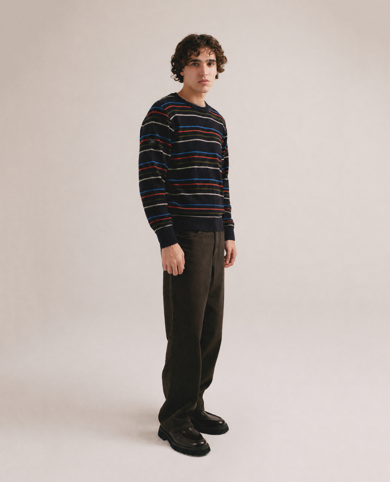Hombre con jersey negro de punto con rayas finas multicolor