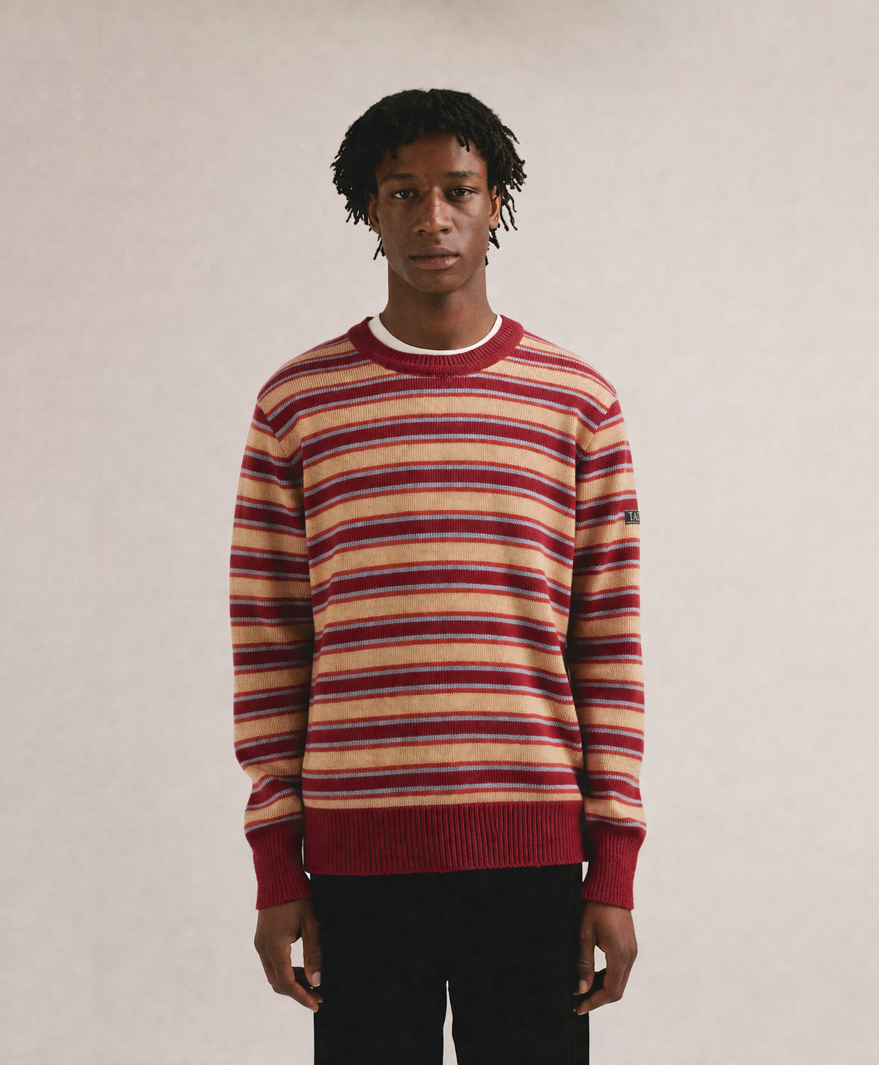 Hombre con jersey de punto a rayas rojas y beige con cuello redondo