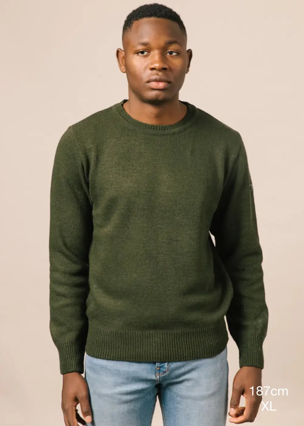 Fotografia de mig cos en la qual es detalla alçada del model (187cm) i la talla de la seva jersei (XL).