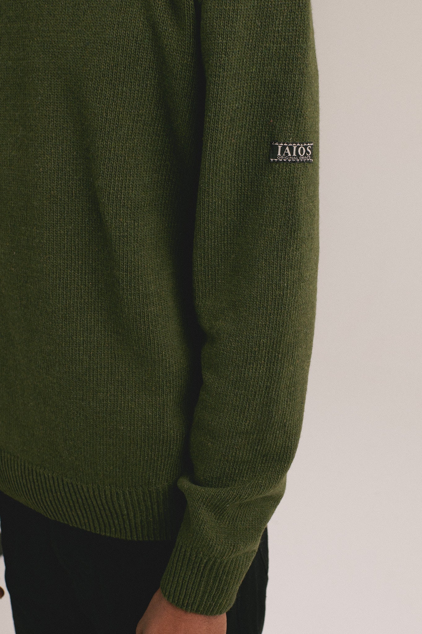 Detalle del suéter de punto verde con acabado suave y corte cómodo de IAIOS.