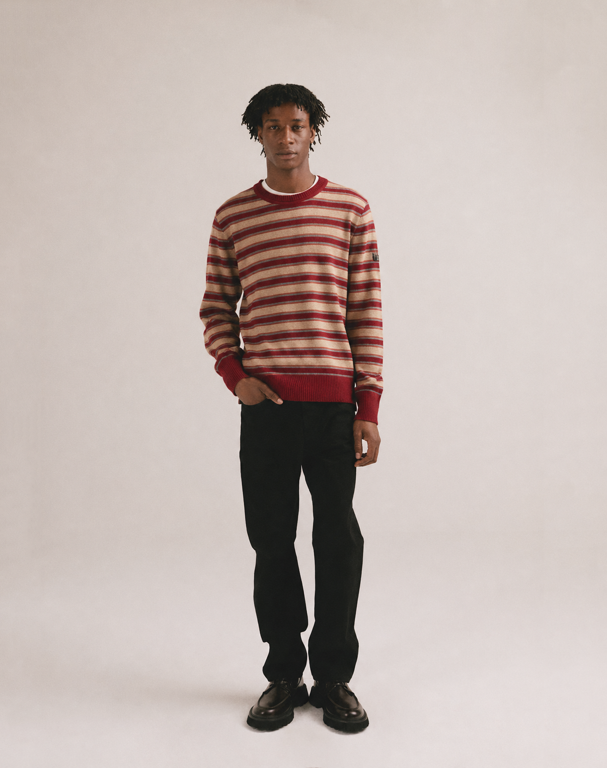 Jersey de punto rayado en tonos rojo y crudo sobre modelo masculino