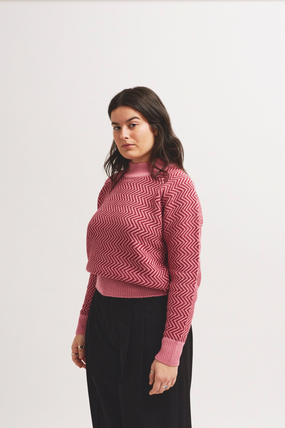 Jersey sostenible de mujer IAIOS rosa con zigzag burdeos y detalles en contraste, hecho en Catalunya (España) con hilo reciclado, ideal para invierno.