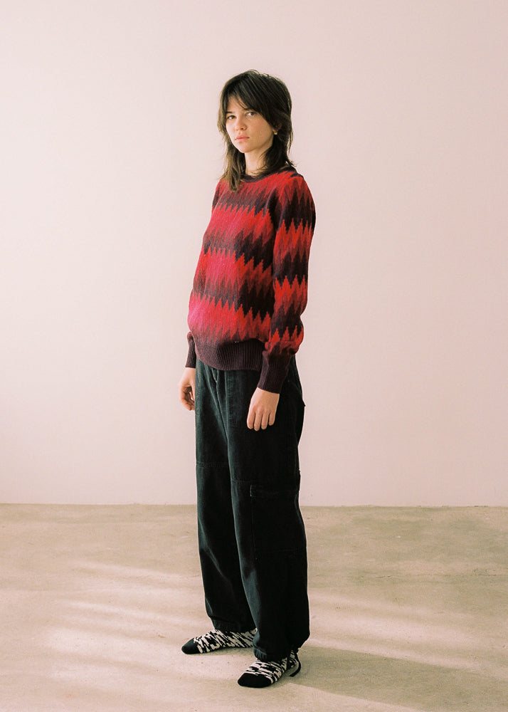 Fotografía de cuerpo entero, jersey combinado con pantalones negros.