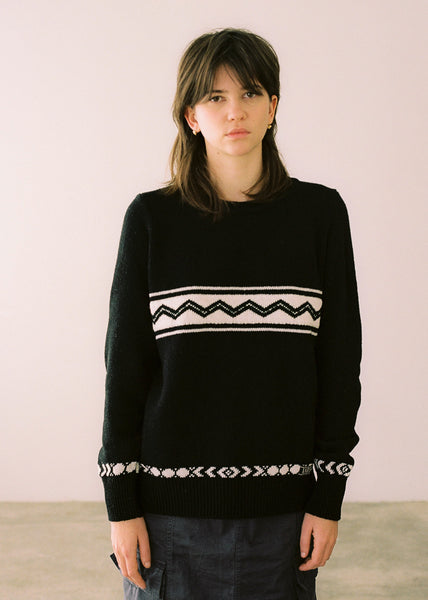 Half-length photograph, black sweater combined with dark skirt.