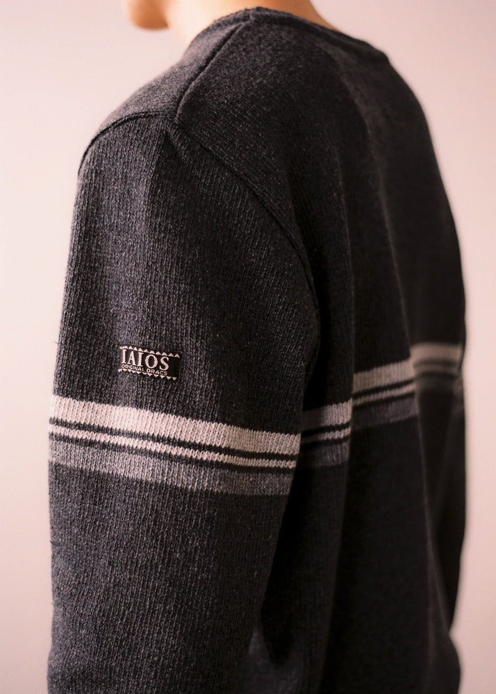 Fotografia de detall en què s' aprecia l' etiqueta amb el logo de IAIOS a la màniga del jersei.
