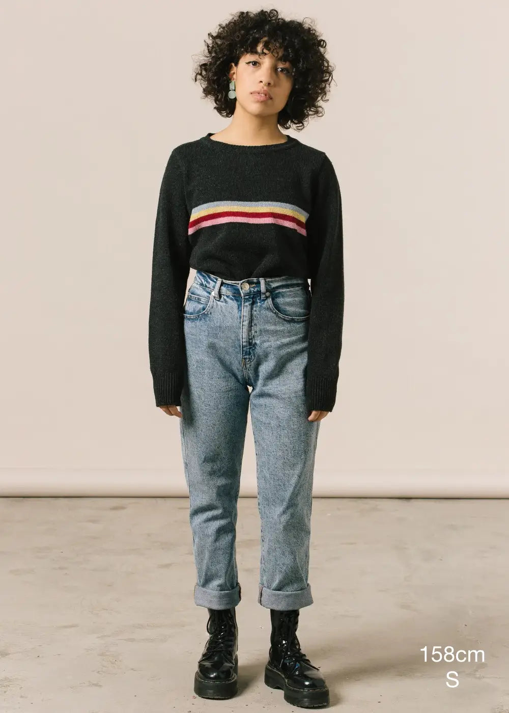 Fotografía de cuerpo entenro en la que se detalla altura de la modelo (158cm) y talla de su jersey (S).
