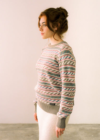 Photo of the sweater worn by the model and photographed in side view, label with logo visible on the hip part.