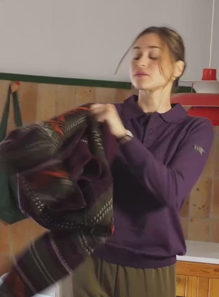 La modelo lleva el jersey IAIOS unisex azul oscuro con cremallera completa y cuello alto, tejido con hilo reciclado en pequeños talleres de Catalunya (España).