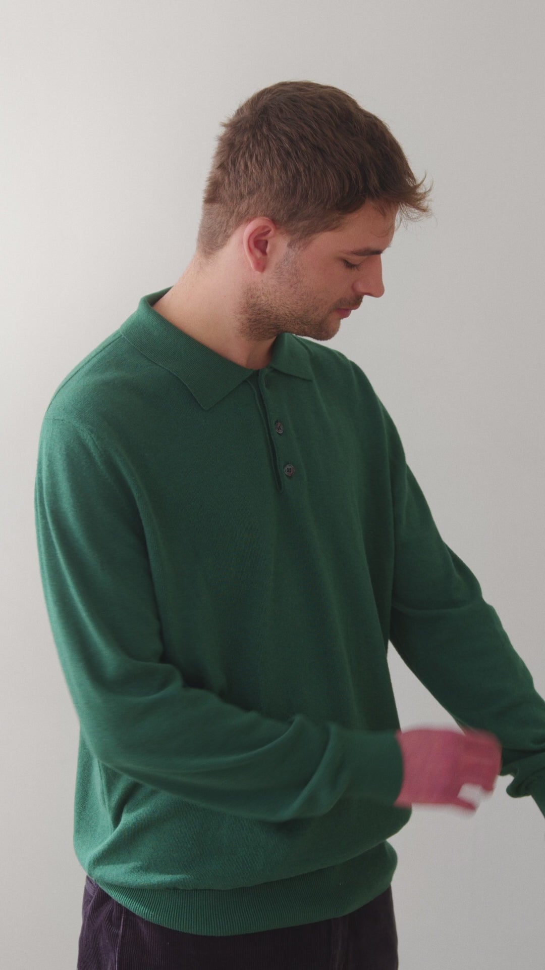 Video en el que el modelo lleva el polo IAIOS unisex verde de algodón reciclado, con cuello clásico y botones, moda sostenible elaborada en talleres de Catalunya (España).