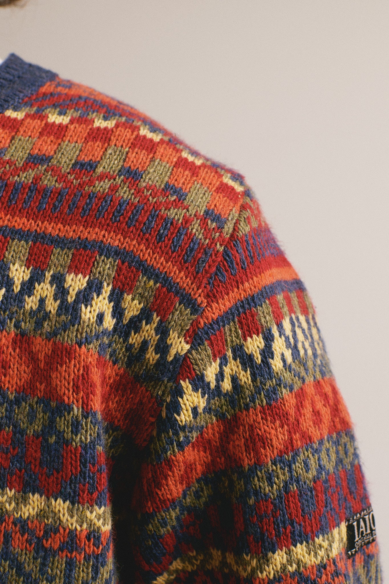Suéter para hombre con estampado nórdico en tonos rojo, azul y amarillo.