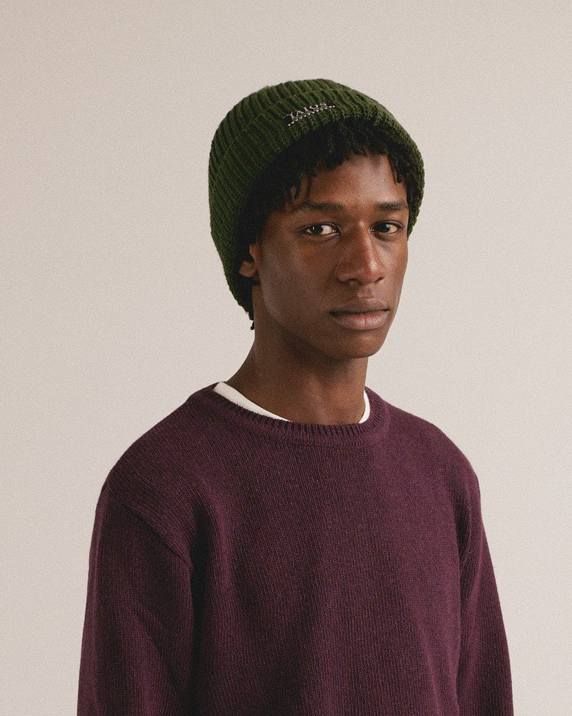 Hombre joven vistiendo jersey granate oscuro de punto con estilo minimalista y look casual moderno.