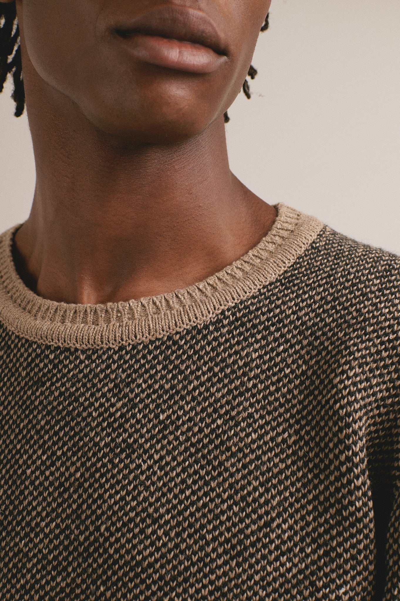 Modelo masculino con suéter marrón de textura fina y conjunto completo
