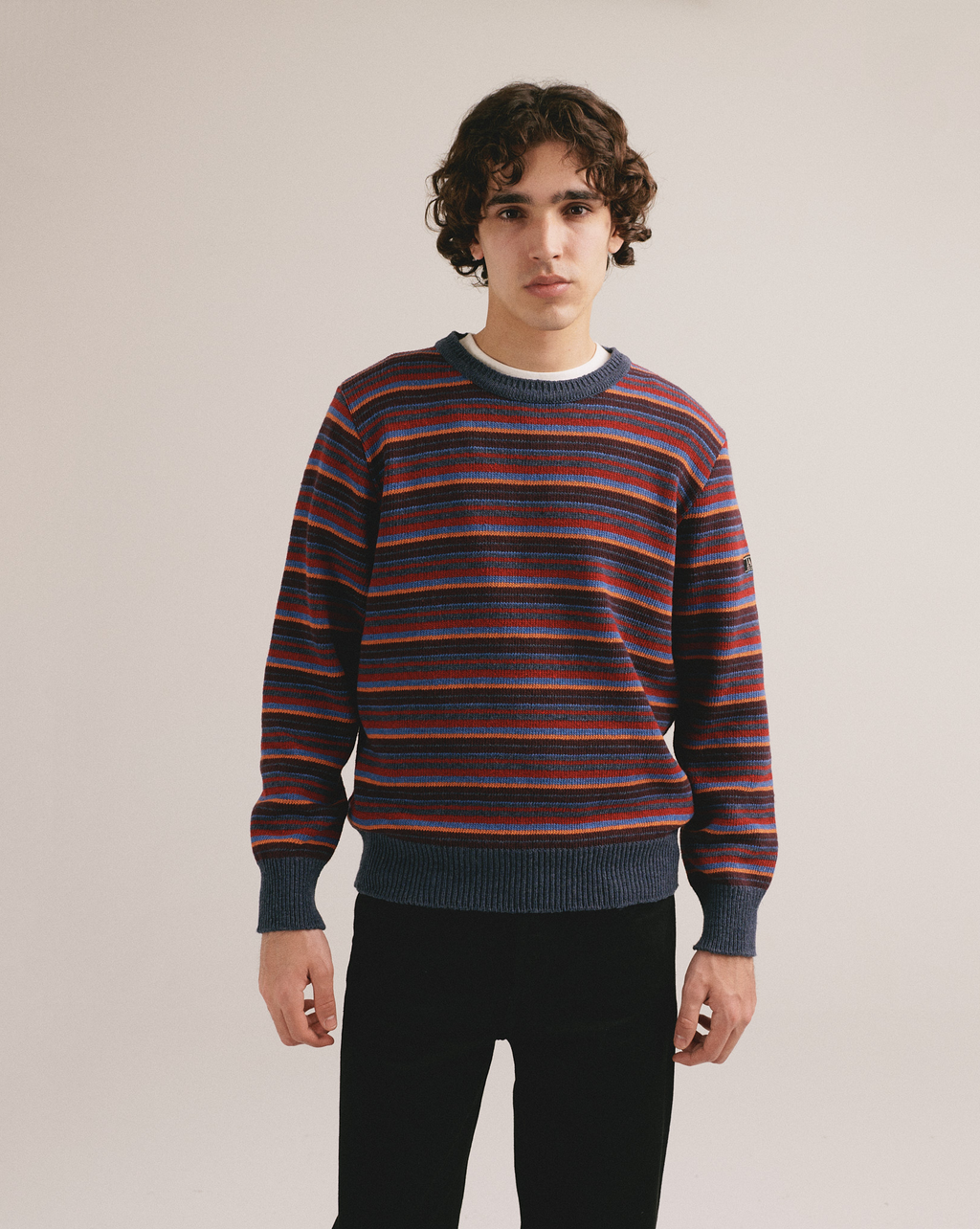 Hombre vistiendo suéter rayado multicolor de estilo casual