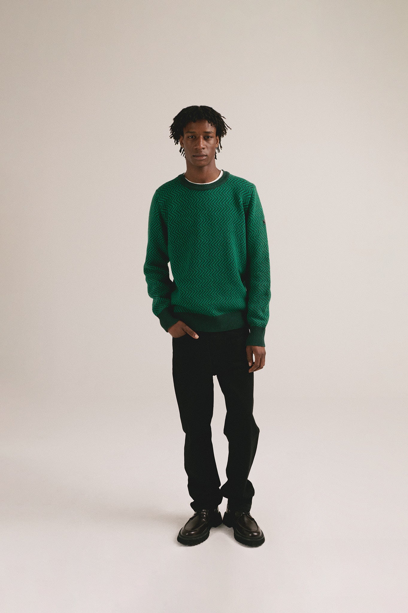 Modelo masculino con suéter de punto verde con diseño en zigzag y manga larga de IAIOS.