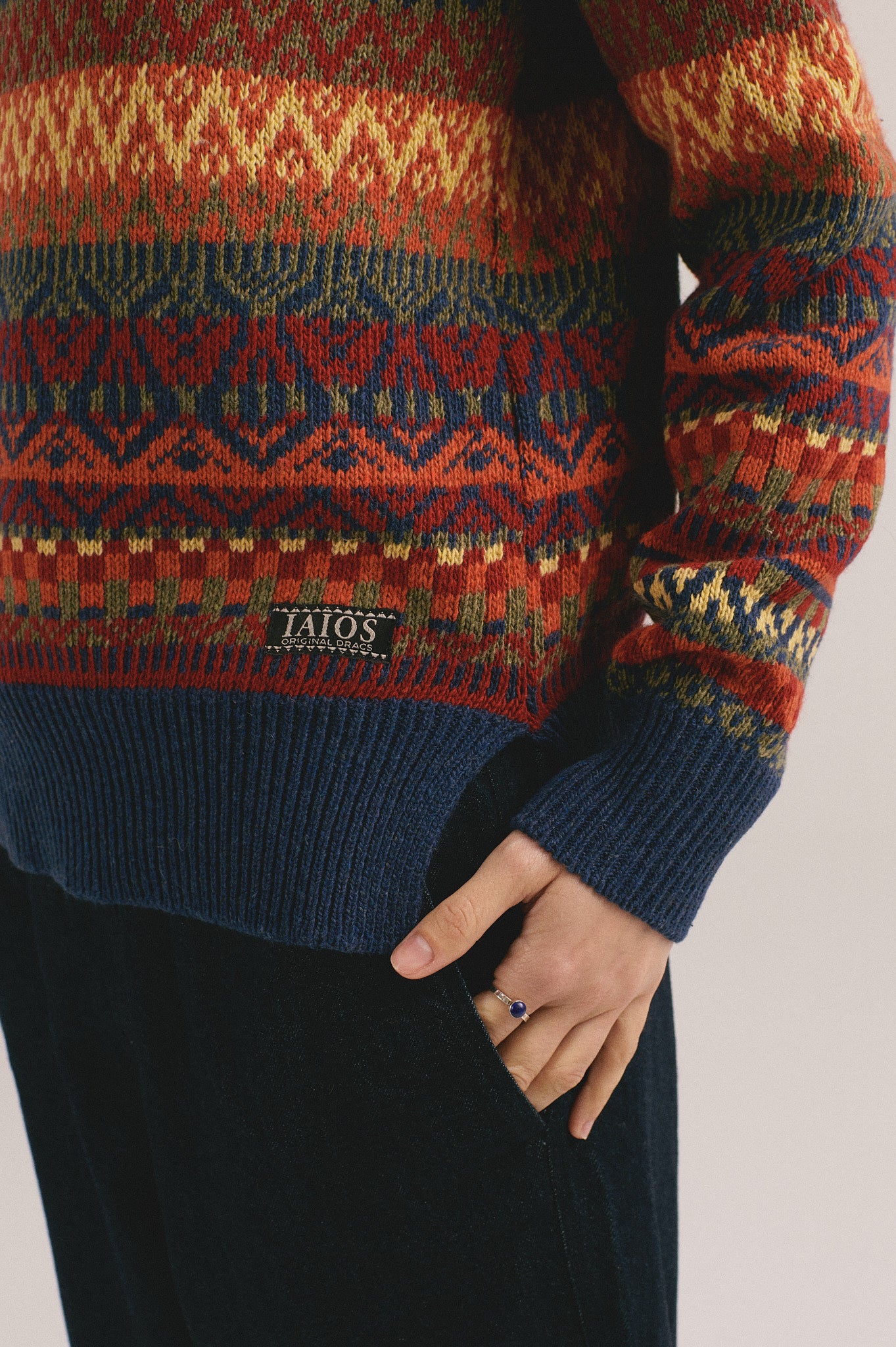 Modelo femenina con suéter de punto en tonos rojo, azul y amarillo con diseño jacquard de IAIOS.