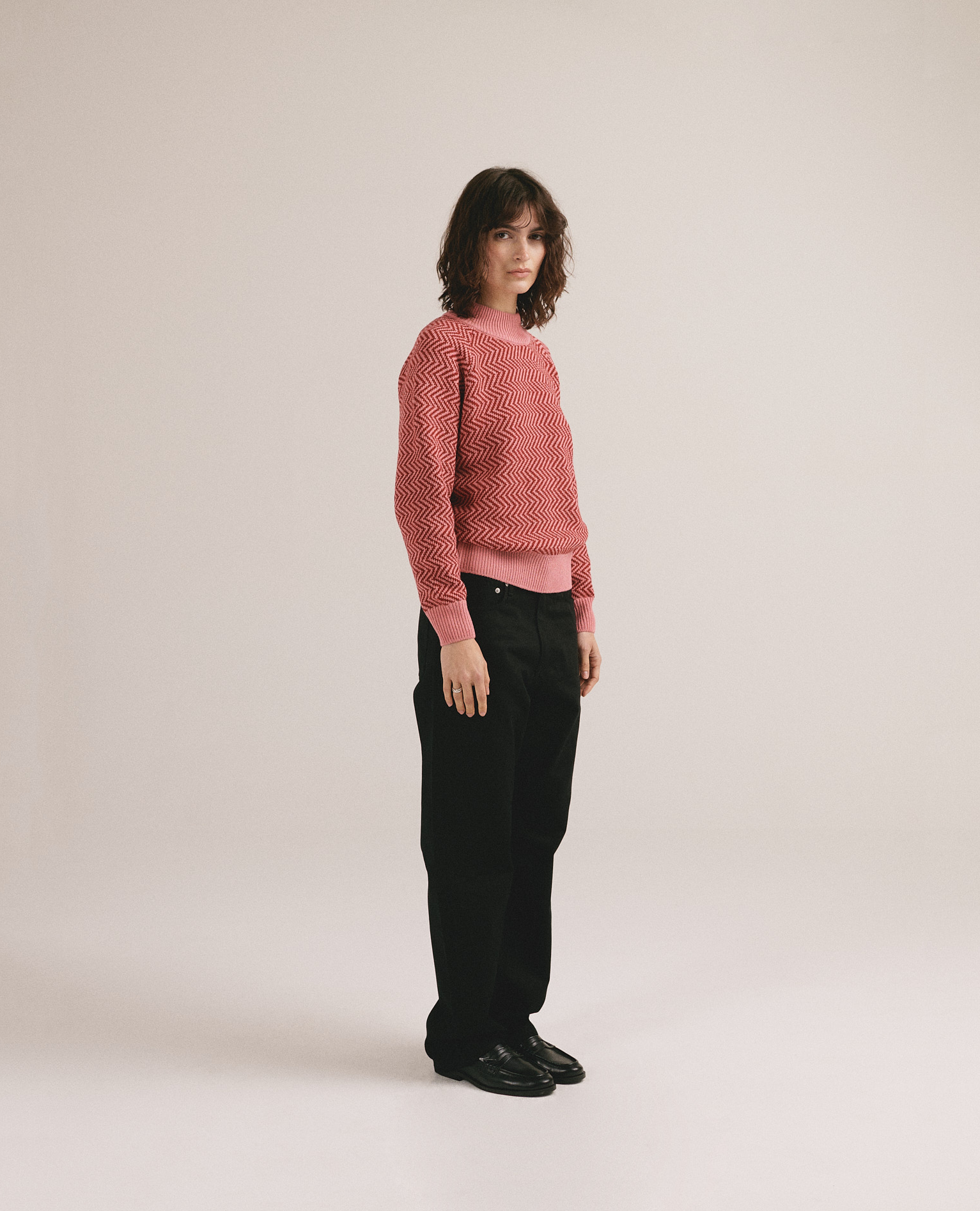 Modelo femenina con suéter de punto en tonos rojos con diseño texturizado de la marca IAIOS.
