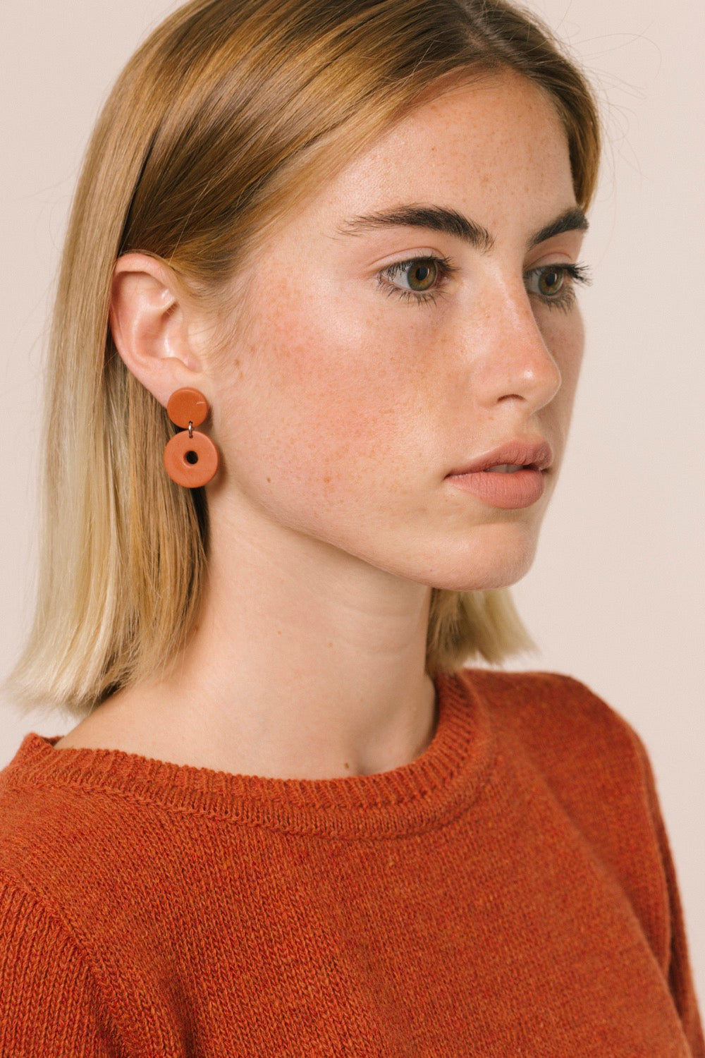 Retrato de la modelo con el jersey. Vemos que el color naranja favorece mucho y puede ser una nota de color en tu armario.