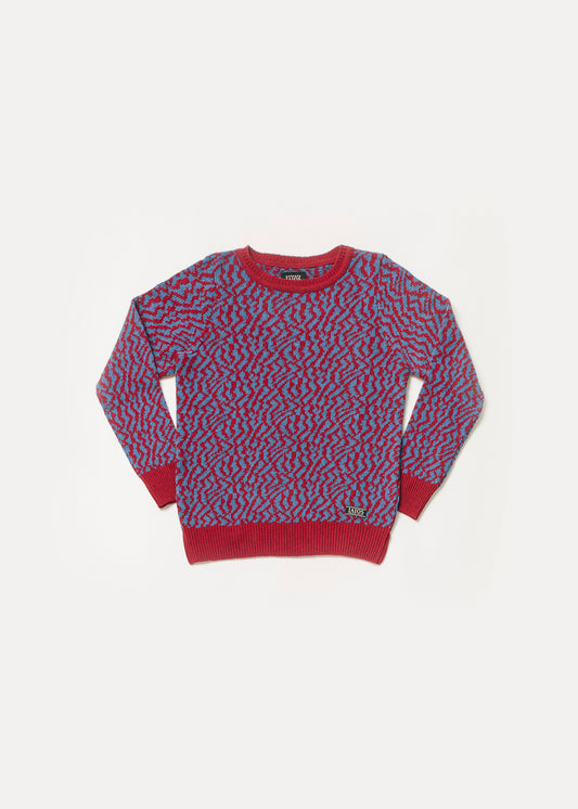 Women's or unisex sweater in red and blue. It is a jacquard that imitates zebra-like spots.
