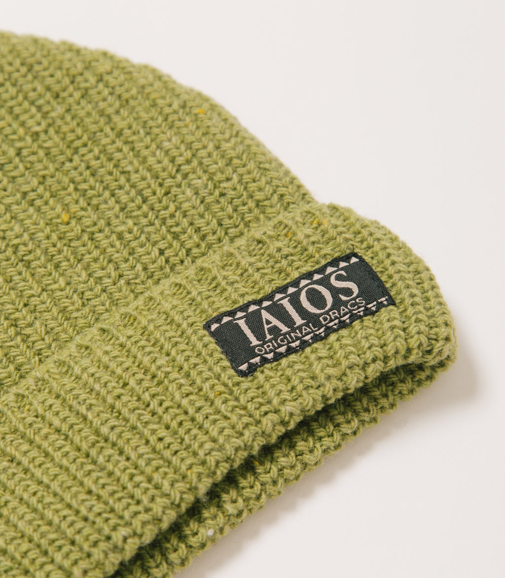 Detalle de la etiqueta IAIOS que lleva el gorro verde