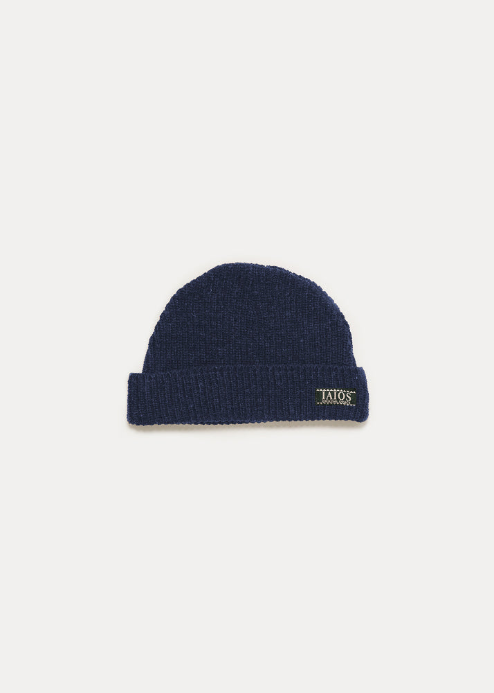 Gorro azul oscuro liso de punto. El diseño es muy básico.
