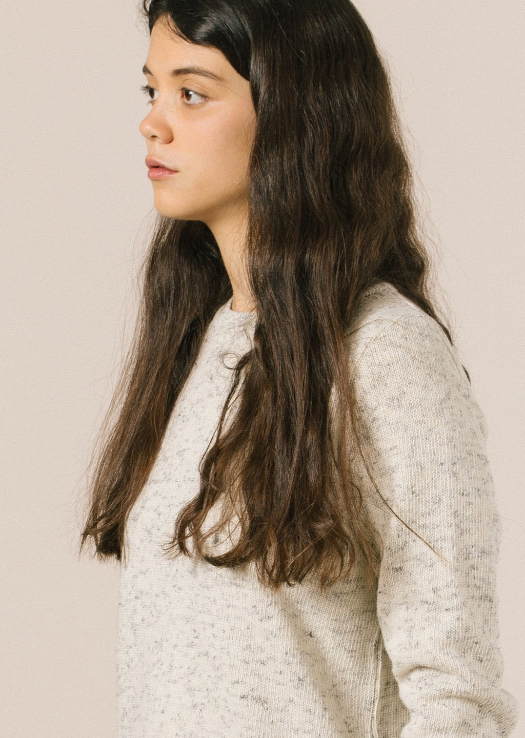 La modelo lleva el jersey de mujer IAIOS blanco liso, patrón femenino básico y recto, moda sostenible hecha en Catalunya (España) con hilo reciclado, ideal para invierno.