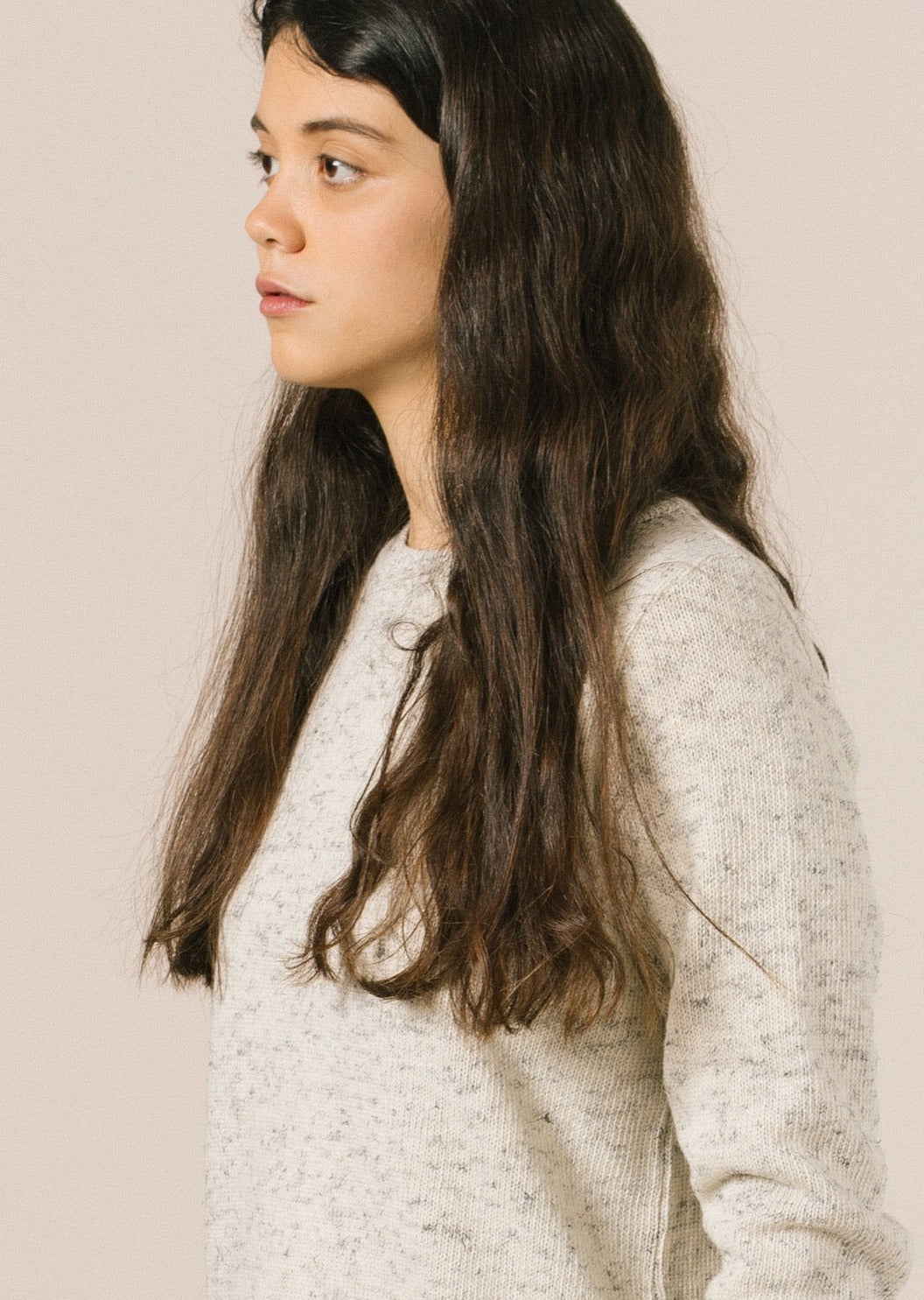 La modelo lleva el jersey de mujer IAIOS blanco liso, patrón femenino básico y recto, moda sostenible hecha en Catalunya (España) con hilo reciclado, ideal para invierno.