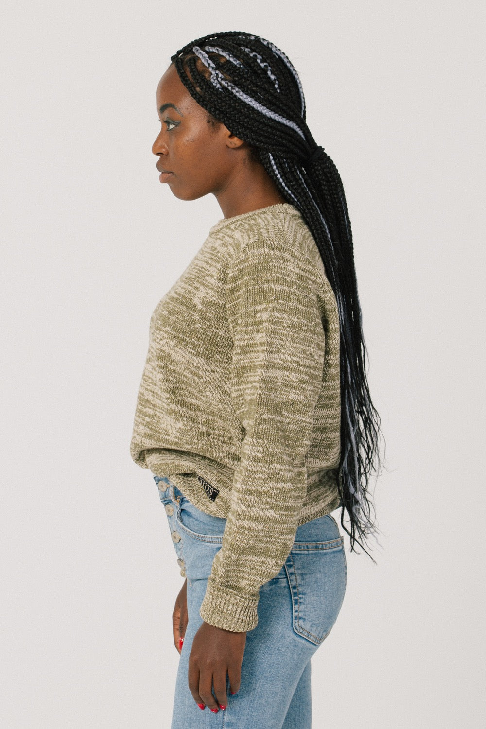 The model from the side. The shape of the sweater is basic and straight so it fits all bodies.