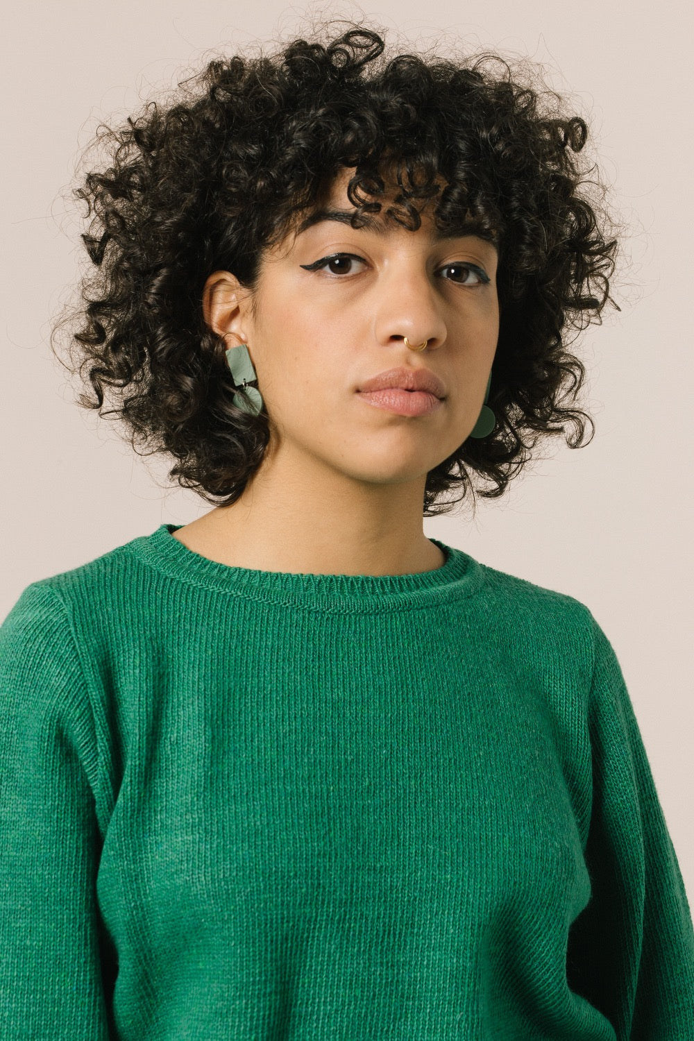 Retrato de la modelo con el jersey. Vemos que el color verde favorece mucho y puede ser una nota de color en tu armario.