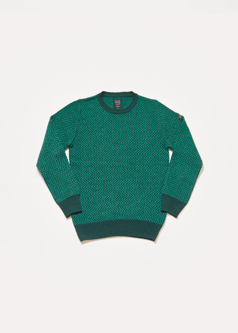 Jersey de punto de hombre o unisex de color verde. El diseño es muy sencillo y consta de un zigzag en lineas finas de color verde botella y verde oscuro. 