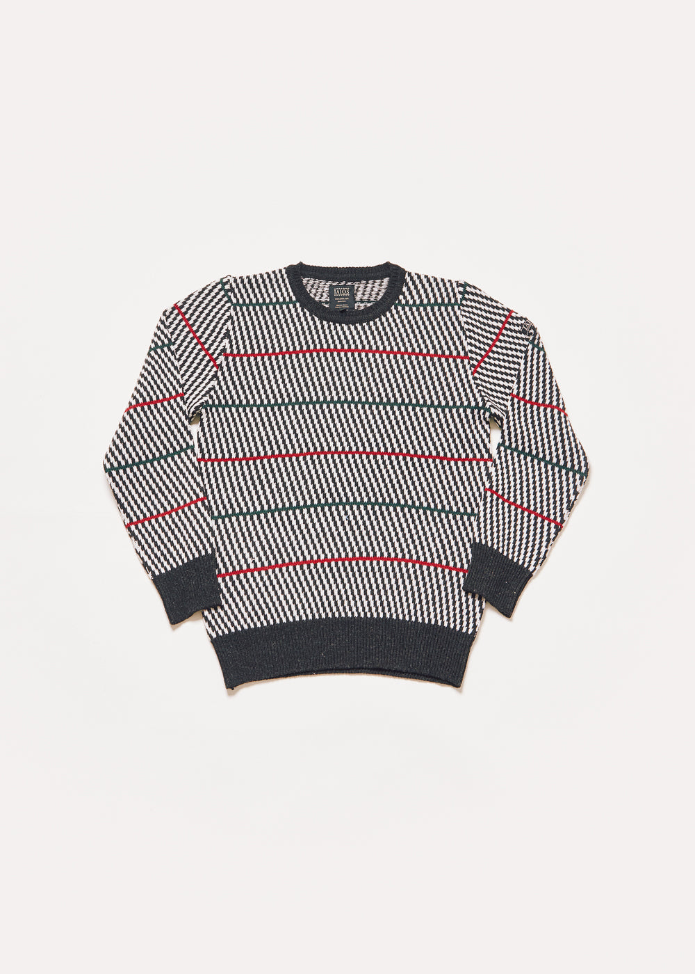 Jersey de punto de hombre o unisex con rallas diagonales de color negro y blanco y unas rayas horizontales verdes y rojas que le dan un toque moderno. 